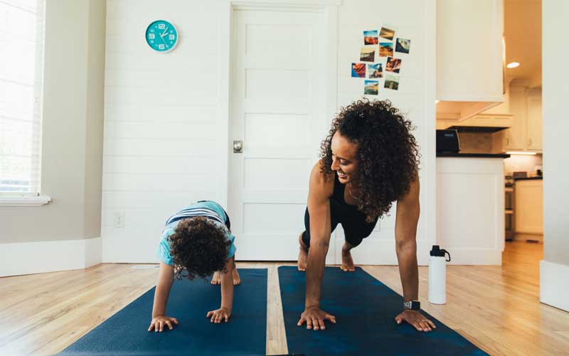 child doing yoga with mom