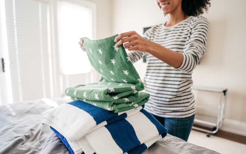 woman folding clean towels