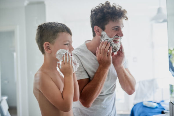 father teaching son how to shave