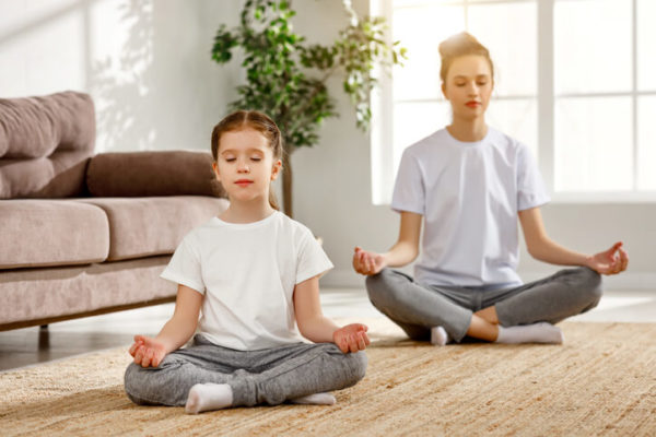 Woman and little girl meditating