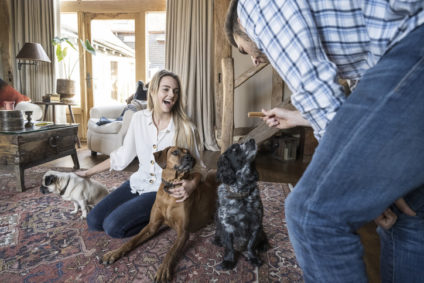 Woman kneeling on Persian rug with relaxed family dogs