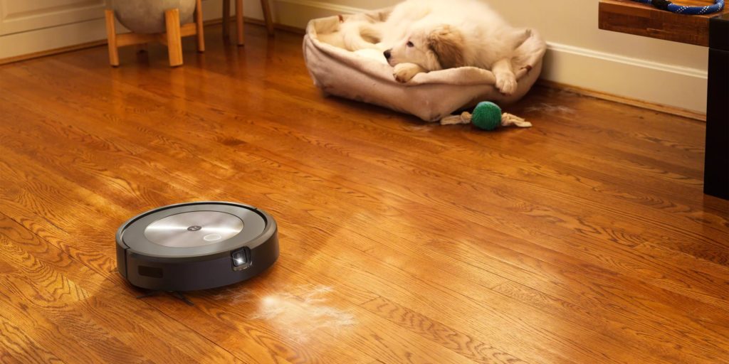 j7 Roomba cleaning hardwood floor with dog in dog bed